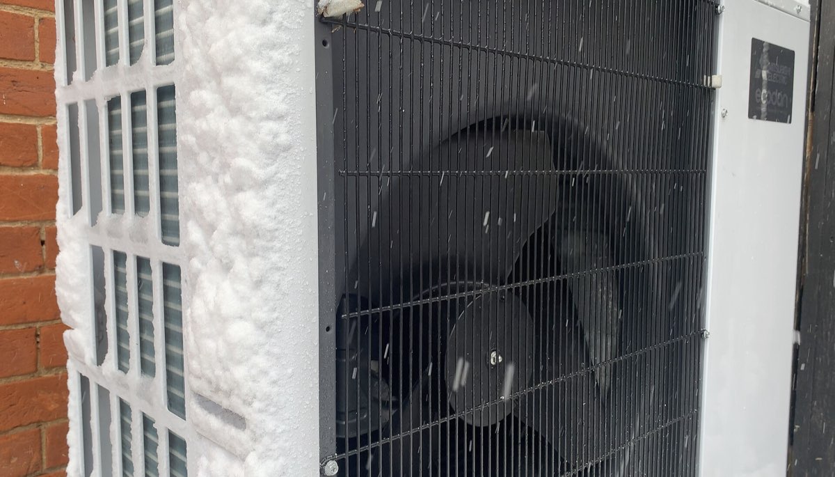 Heat pump outdoor unit covered in frost and snow